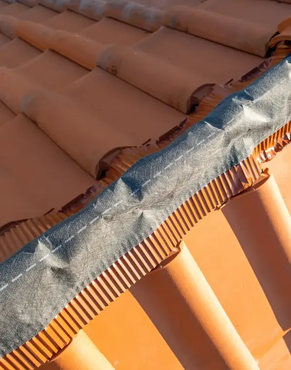 Chantier de rénovation de toiture en cours, tuiles et closoir de faîtage
